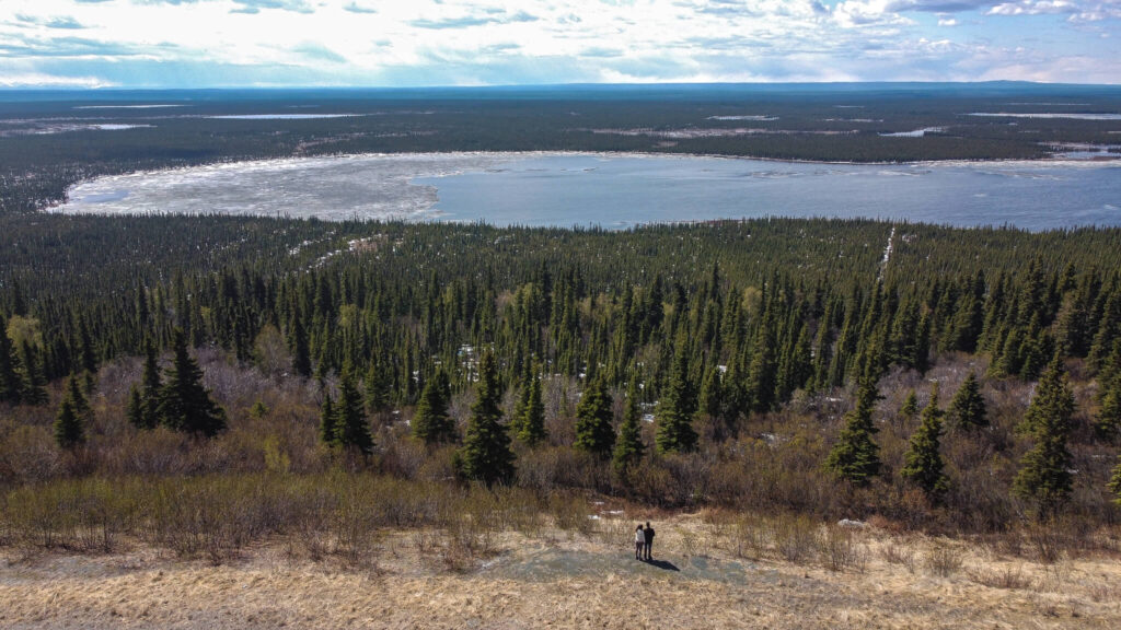 Road trip en Alaska, vue drone de Manon et Quentin devant un lac entouré de forêts