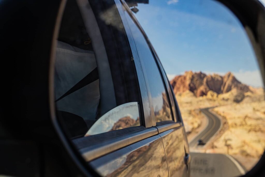 vue d'une route désertique dans le rétroviseur d'une voiture